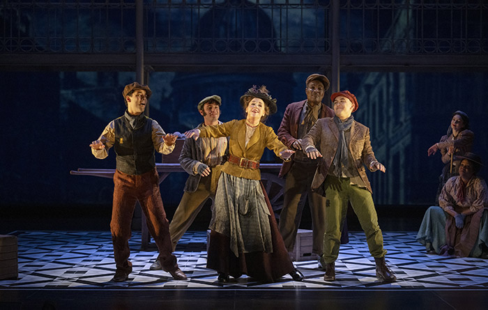 Kristi Frank as Eliza Doolittle with (l to r) JJ Gerber, Gryphyn Karimloo, Allan Louis, Graeme Kitagawa and members of the cast (Shaw Festival, 2024). Photo by David Cooper.